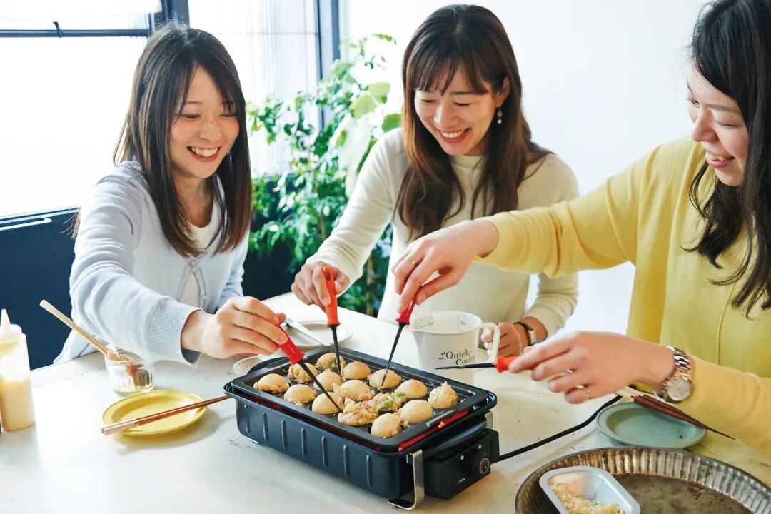 朋友们围坐制作章鱼烧的实拍场景